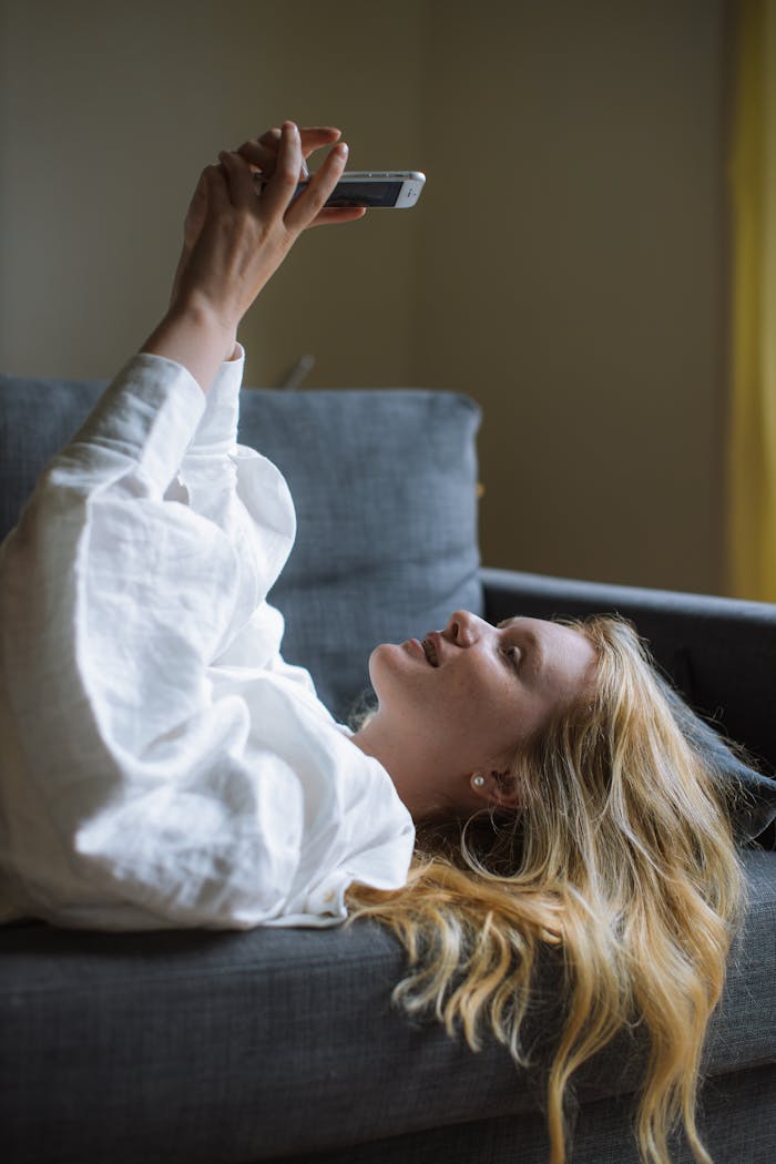 Woman in White Dress Shirt Lying on a Sofa